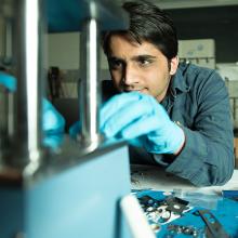 Graduate student works in machine lab