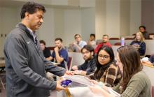 Professor showing student a prop in the classroom
