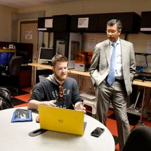 Business man works with student entrepreneur at a laptop